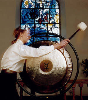 Music in Sacred Practice using Tam Tam, against backdrop of Chagall window